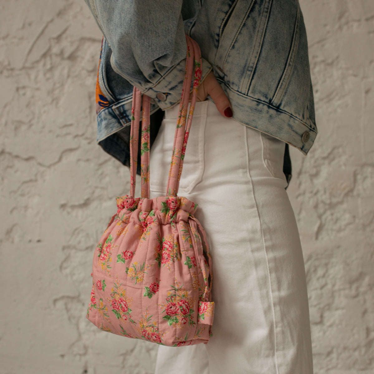 Sac bourse Manhattan en tissu matelassé fleuri rose porté à la main – patron de couture Ikatee